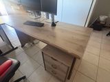 a desk with two monitors and a chair in the room