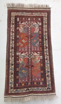 an old rug hanging on a wall with a white background