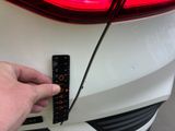 a hand that is holding a ruler on the front of a car