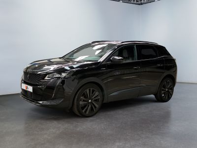 un SUV noir garé dans un showroom aux murs blancs