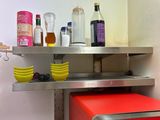 a red microwave sitting on a metal shelf in a kitchen