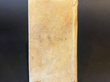 an old book sitting on top of a table next to a black table