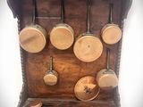une étagère en bois sur laquelle sont suspendus des casseroles et des poêles