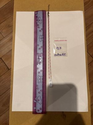 une boîte ornée d'un ruban violet et d'une étiquette blanche