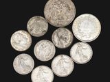 several silver coins are arranged in a circle on a black surface