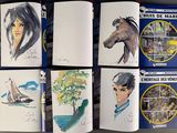 several books with drawings of people and animals on them on a table
