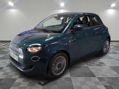 the small blue car is parked on a checkered tile floor