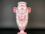 un vase rose et blanc posé sur une table noire