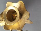 a gold candle holder with a flower on top of it