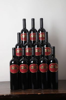 des bouteilles de vin rouge sont posées sur une table en bois devant un mur blanc