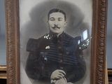 portrait of a man in a military uniform sitting in front of a wooden easel