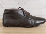 des bottines en cuir marron à lacets posées sur une table en bois