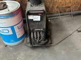 a small machine that is on the ground next to a can of paint