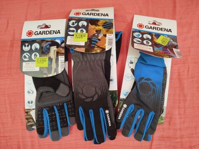 trois paires de gants de jardinage sont posées sur un tissu rose