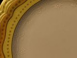 yellow and white dinner plate with gold trim on a black background