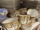 many cups and saucers on a shelf in a store