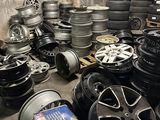 tires and rims are stacked on pallets in a garage