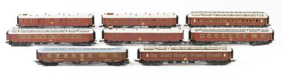 six toy trains are lined up in a row on a white surface