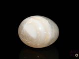 a white marble ball sitting on top of a black surface