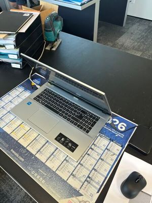 un ordinateur portable posé sur un bureau, avec une souris dessus
