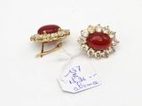 pair of red and white stone earrings with a price tag on a white surface