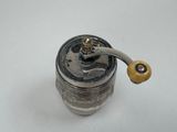 a silver pepper mill with a wooden handle on a white table