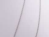 silver plated chain with a heart pendant on it on a white surface
