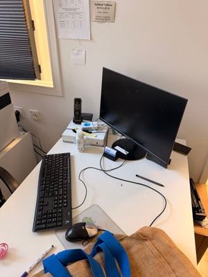 a desk with a keyboard, mouse, headphones and a monitor on it