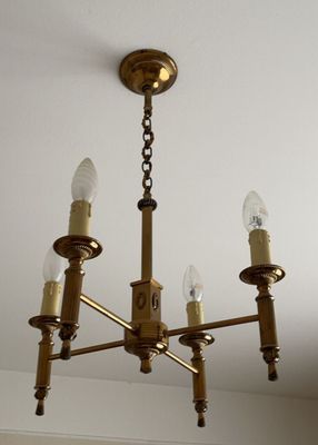 Lustre à quatre bras de lumière en métal doré, à décor de co…
