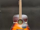 an acoustic guitar sitting on a stand in front of a black background