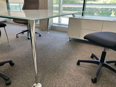 des tables et des chaises dans un bureau avec vue sur l'extérieur