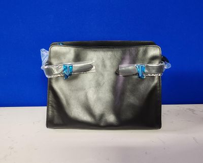 un sac à main noir muni de deux fermetures éclair, posé sur une table