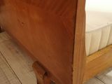 a wooden bed frame with a mattress on top of it