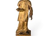 an antique wooden statue of a woman holding a book
