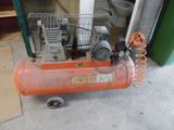un petit compresseur d'air orange posé par terre
