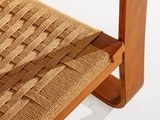 the seat of a wooden chair with a woven seat pad on it