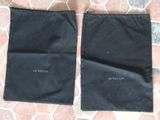 two black bags sitting on top of a tiled floor next to each other