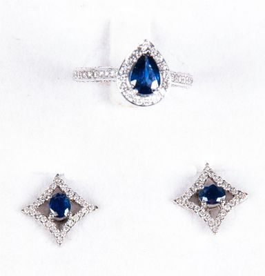 trois bijoux en saphir bleu et diamants posés sur un fond blanc