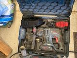 une trousse à outils posée par terre à côté d'autres outils