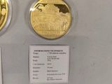 two gold coins on display in a glass case