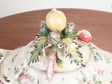 a white bowl with a flower on top of it on a table