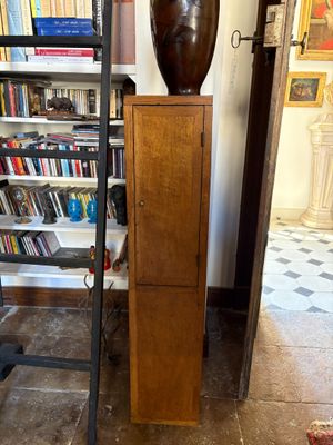 a tall wooden cabinet in front of a bookshelf