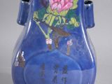 a blue vase with a pink flower on it