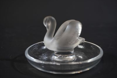a glass swan sitting on top of a glass plate