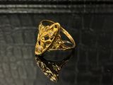 gros plan d'une bague en or posée sur une surface noire