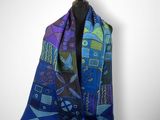 une écharpe ornée d'un motif bleu et violet à côté d'une fleur