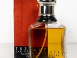 l'image d'un flacon de parfum posé à côté d'une boîte
