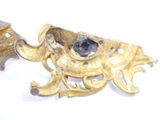 a gold candle holder with a blue stone in it