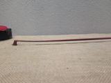 a red stick sitting on a table next to a black tape