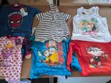 de nombreux vêtements d'enfants posés sur une table dans une pièce